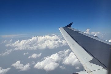 Fototapeta premium View from a plane to its wing during the flight above the clouds