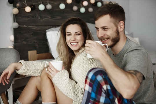 Young couple drinking coffee in bed