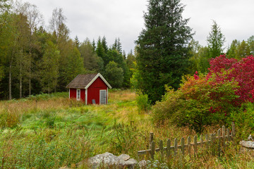 Wooden red cottage houses in scenery of Sweden