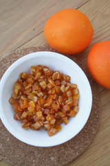 Candied orange peel in a bowl on wooden table. 
