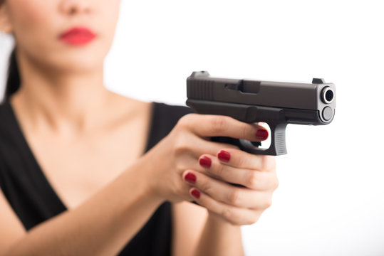 young woman asian girl holding a gun aiming at the gun, with selective focus