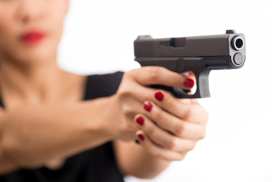 young woman asian girl holding a gun aiming at the gun, with selective focus