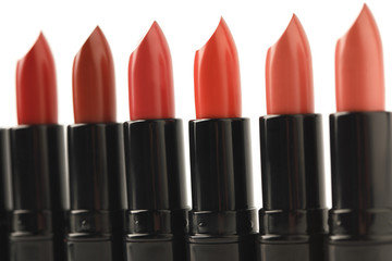 Obraz premium close-up shot of row of red lipsticks of various shades isolated on white