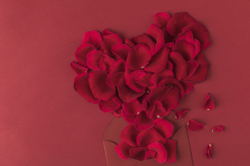 top view of heart made of roses petals and envelope isolated on red, st valentines day concept