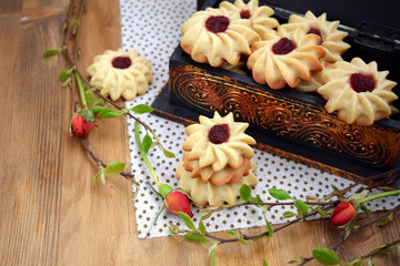 Obraz na płótnie Canvas Shortbread cookies with jam on a cloth surrounded by branches
