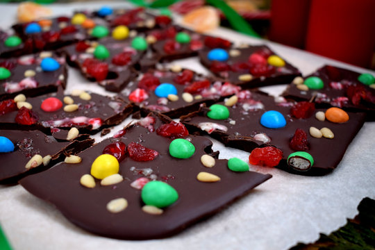 Dark chocolate bark with multicoloured drops, nuts and dried fruits broken into pieces