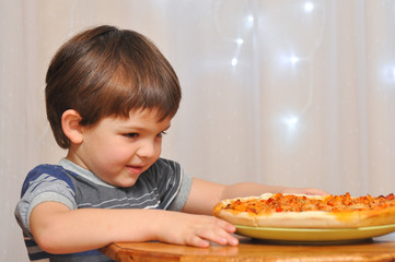 Silly boy eats pizza for dinner. Boy order fast food.