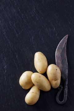 Raw potatoes with old knife