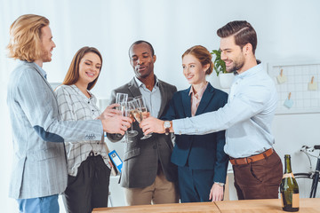 business team celebrating with beverage in glasses at office space