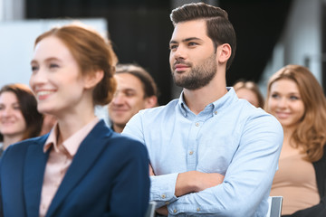 Caucasian man in blue shirt looking away while sitting at meeting