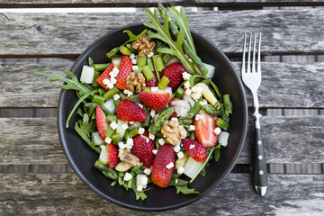Fresh salad of asparagus, strawberries, rocket, feta cheese and walnuts
