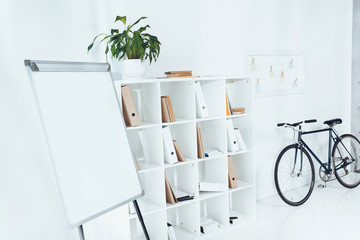 flipchart with bicycle and wooden shelves in empty office