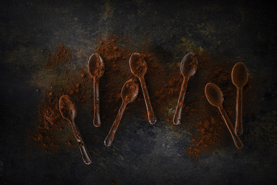 Seven chocolate spoons sprinkled with cocoa