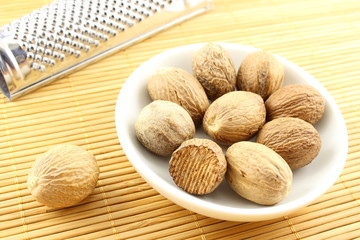 nutmeg seeds in a small white bowl