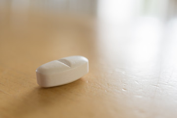 Fototapeta na wymiar A white tablet on a wooden table