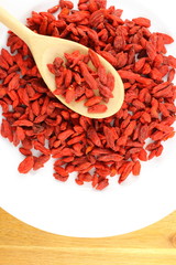 dried goji berries on a wooden spoon