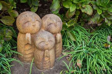Statue of 3 little praying monks in the forest