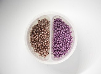 Beautiful colorful jewelry making beeds on white background. Shallow depth of field. Hand craft supplies.