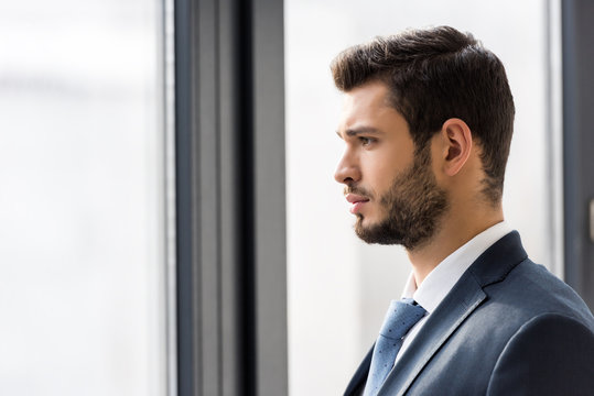 side view of handsome young businessman looking at window