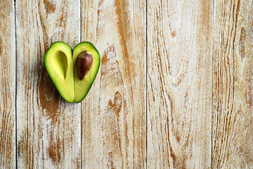 Heart shaped avocado on wooden background © molenira