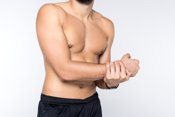 Obraz premium cropped shot of young man showing his muscles isolated on white