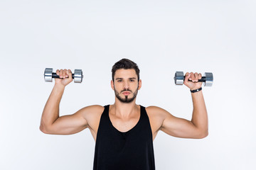 Fototapeta na wymiar handsome young man working out with dumbbells isolated on white