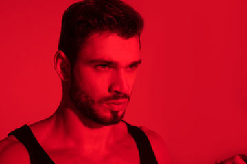 Obraz premium close-up portrait of handsome young man under red light