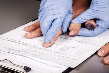 police takes fingerprints of a criminal
