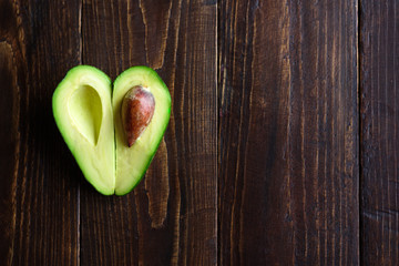 Heart shaped avocado on wooden background © molenira
