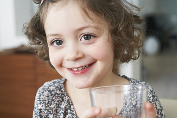 Portrait of smiling little girl with glass