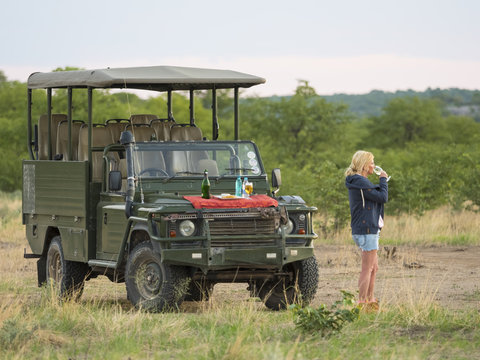 Namibia, Outjo, tourist drinking glass of champagne in Ongava Wild Reservat
