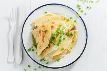 Pancakes with cottage cheese and chive on white table © shaiith