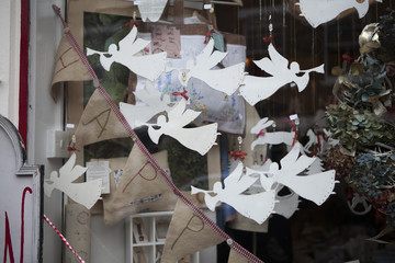 Paper angels trumpet into pipes. Paper figures as a shop window decoration in Christmas