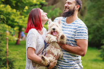 Young happy family in t-shirts with dog outside