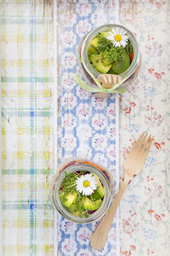 Springtime salad in glasses, avocado and cress, daisy