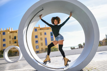 Black woman on roller skates riding outdoors on urban street