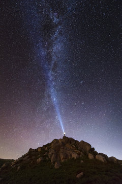 Man Illuminating Sky On Starry Night With Blue Ray