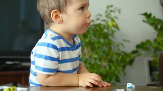 Baby boy talking while playing with plasticine at home
