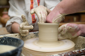 Hands of a potter, creating a pot of clay
