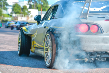Drift car standing at the start line, waiting for race to begin. Rally car warming up the tires, blue smoke all around
