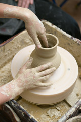 Hands of a potter, creating a pot of clay