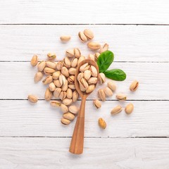 Pistachios nuts on a white wooden background. Healthy snacks. Top view. Free space for text.