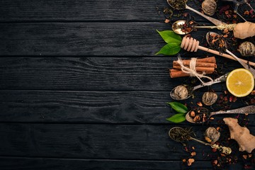 Assortment of dry teas and fragrant herbs and spices. On a wooden background. Top view. Copy space.