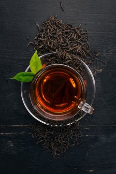 A cup of black tea on a wooden background. Top view. Copy space.