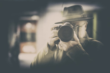 Photographer with hat mirrored in window display