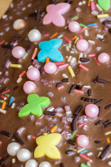 Closeup of birthday cake icing with colourful decoration – from above