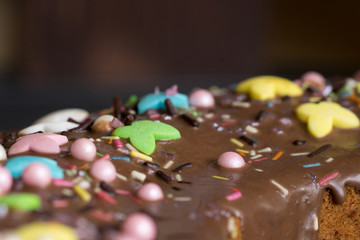Obraz na płótnie Canvas Closeup of birthday cake icing with colourful decoration – side view