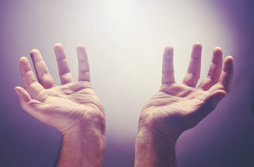 Hands raise with the palm opened up, worship or pray for good things under the light ray from...