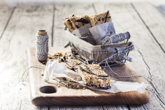 Homemade granola bars with amaranth and black chocolate on wooden board
