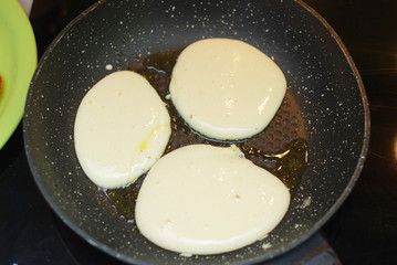 Preparing Breakfast. Raw Pancakes baked in a frying pan.